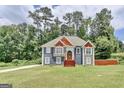 Charming two-story home with mature trees, gray siding, and stone accents at 3685 Washington Rd, East Point, GA 30344
