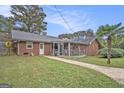 Spacious backyard featuring a screened porch, lush lawn, and a mature palm tree at 1083 Hampton Rd, Hampton, GA 30228