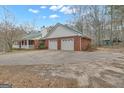 Side view of a brick home featuring a spacious two-car garage and an expansive driveway at 81 Bowers Rd, Moreland, GA 30259