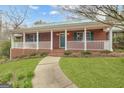 Charming brick home featuring a covered front porch with white railing and a walkway to the front door at 81 Bowers Rd, Moreland, GA 30259