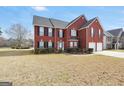 Classic brick home boasts black shutters, a well-maintained lawn, and an inviting two-story facade at 1233 Kern Cv, Mcdonough, GA 30253