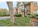 Brick townhome with green shrubs and a view of the parking lot at 3802 Austin Park Ln, Decatur, GA 30032