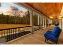 Relaxing covered porch featuring comfortable seating, wooden floors, and a scenic view of the surrounding landscape at 203 Shelby Ln, Fayetteville, GA 30215