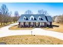 Stately brick home with a well-manicured lawn and a circular driveway offering curb appeal at 111 Dixson Rd, Bowdon, GA 30108
