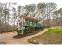 View of a charming two-story home featuring a welcoming front porch and driveway at 12 Paces Lakes Overlook, Dallas, GA 30157