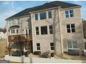 View of a backyard featuring light brick, a deck, and outdoor seating area at 4604 Mossey Dr, Stonecrest, GA 30038