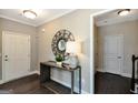 Bright foyer showcasing console table with modern lamp, decorative mirror, and access to staircase at 2446 Naples St, Hoschton, GA 30548
