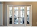 Elegant french doors open to reveal home office with stylish desk, chair, and abundant natural light at 2446 Naples St, Hoschton, GA 30548