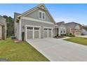 Side view featuring a long driveway leading to a three-car garage, complemented by a green lawn at 208 Cottonwood Cir, Peachtree City, GA 30269