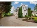 Spacious driveway leads to a three car garage with a lovely landscaped yard at 675 Falls Lake Dr, Alpharetta, GA 30022