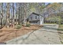 Charming two-story home with gray siding, surrounded by mature trees and a long driveway at 1967 Levgard Ln, Riverdale, GA 30296