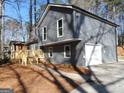 Well-maintained home with gray siding, a new deck, and an attached garage, on a large lot at 1967 Levgard Ln, Riverdale, GA 30296