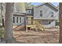 Beautiful two-story house with gray siding, wooden deck, and mature trees in a serene setting at 1967 Levgard Ln, Riverdale, GA 30296