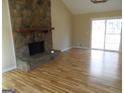 Living room showcasing a stone fireplace and a glass sliding door leading to the outdoors at 1967 Levgard Ln, Riverdale, GA 30296