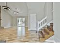 Bright living room features wood floors, vaulted ceilings, modern lighting and a sliding door to a deck at 1967 Levgard Ln, Riverdale, GA 30296
