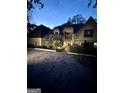 Exterior of a home at night with a brick driveway and decorative landscaping at 275 Old Mill Ct, Fayetteville, GA 30214