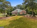 Well maintained brick home with mature landscaping, lush lawn, and classic architectural features at 830 Streamside Dr, Mcdonough, GA 30252