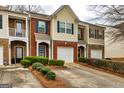 View of townhomes featuring brick and siding facades, two-car garages, and landscaped front yards at 2786 Snapfinger Mnr, Decatur, GA 30035