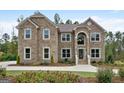 Beautiful two-story brick home with a landscaped front yard and blooming flower beds at 5915 Langdale Chase # 16, Douglasville, GA 30135