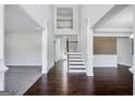 Bright, two-story foyer with hardwood floors, a staircase, and white wainscoting creating an open and airy feel at 5905 Langdale Chase # 17, Douglasville, GA 30135