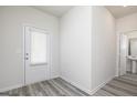 Bright entryway with a back door, light gray wood floors, and a partial view of the bathroom at 287 Limestone Circle, Conyers, GA 30013