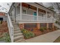 Beautiful home exterior featuring a welcoming front porch, brick foundation, and landscaped front yard at 5118 N Pratt St, Covington, GA 30014