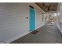 Inviting covered front porch featuring a stylish wood ceiling and a bright blue front door at 5118 N Pratt St, Covington, GA 30014