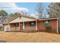 Cozy front porch of a brick home with green shutters, white porch railings, and a decorative wreath on the front door at 979 Walnut Creek Ln, Jonesboro, GA 30238