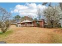 Quaint single-story brick home with a front porch, offering a welcoming curb appeal and surrounded by mature trees at 979 Walnut Creek Ln, Jonesboro, GA 30238