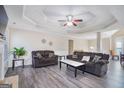 Inviting living room with trey ceiling, hardwood floors, ceiling fan, and comfortable sofas at 1421 Saint Charles Ct, Conyers, GA 30094