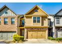 Two-story home featuring a stone-accented facade, two-car garage, and manicured landscaping at 2325 Thackery Rd, Snellville, GA 30078