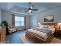 Spacious main bedroom with a wooden bed frame, ceiling fan, and lots of natural light at 141 Muirwood Dr, Temple, GA 30179