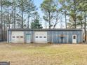 A large metal barn building featuring multiple garage doors, perfect for storage or workshop space at 6393 Walker Rd, Riverdale, GA 30296