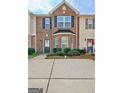 Beautiful brick townhouse featuring a bay window and well-maintained landscaping at 1915 Grove Way, Hampton, GA 30228
