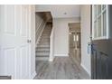Inviting foyer with stylish gray wood-look floors and staircase leading to the upper level at 1915 Grove Way, Hampton, GA 30228