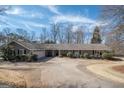 Charming home featuring a long driveway, manicured landscaping, and a welcoming facade with neutral tones and classic architectural details at 311 Pinemount Dr, Peachtree City, GA 30269
