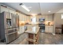 Updated kitchen with stainless steel appliances, granite counters, island and custom cabinets for a blend of style and functionality at 311 Pinemount Dr, Peachtree City, GA 30269