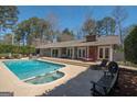 A stunning in-ground pool features an attached spa and ample lounge space, perfect for outdoor relaxation and entertainment at 311 Pinemount Dr, Peachtree City, GA 30269