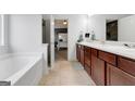 Bright bathroom showcasing a double sink vanity and separate tub with tile flooring at 70 High Point Way, Hiram, GA 30141