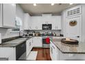Well-lit kitchen boasts granite countertops, modern appliances, and white cabinetry at 70 High Point Way, Hiram, GA 30141