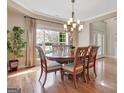 Elegant dining room with hardwood floors, large window offering natural light, and stylish chandelier fixture at 135 Edgewater Trl, Fayetteville, GA 30215