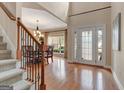 Grand foyer features hardwood floors, staircase, and a dining area with large windows and French doors at 135 Edgewater Trl, Fayetteville, GA 30215