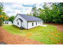 Spacious backyard featuring professionally landscaped lawn, new home construction, and a charming white exterior at 3264 Greenhill Ct, Villa Rica, GA 30180