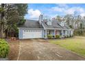 Traditional-style home featuring a two-car garage, dormer windows, and a covered front porch with a vibrant red door at 10 Allen Oaks Way, Covington, GA 30016