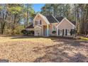 Traditional two-story home with well-maintained lawn, mature trees, and a bright blue front door provides a welcoming curb appeal at 135 Weeping Willow Way, Tyrone, GA 30290