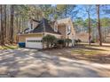 View of this home's side facade featuring an attached two car garage and a well-maintained private driveway at 135 Weeping Willow Way, Tyrone, GA 30290