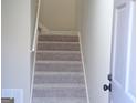 Carpeted staircase featuring a metal railing, a partially visible door and an air conditioning unit vent at 2401 Northlake Ct, Atlanta, GA 30345