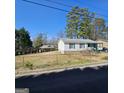 A single-story home with a yard enclosed by a chain-link fence and some mature trees at 4748 Ash St, Doraville, GA 30340