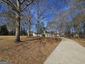 Long driveway leading to a quaint home nestled among mature trees, offering privacy and curb appeal at 245 Kim Trail, Stockbridge, GA 30281