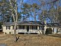 Inviting single-story house featuring a covered front porch and classic black shutters, set in a leafy neighborhood at 245 Kim Trl, Stockbridge, GA 30281